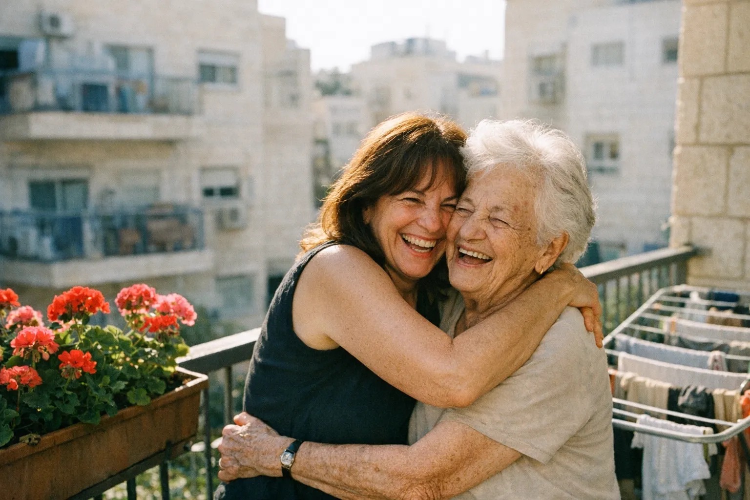 בת ואמא מבוגרת מחובקות וצוחקות במרפסת